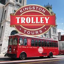 A red trolley bus in front of a building

Description automatically generated