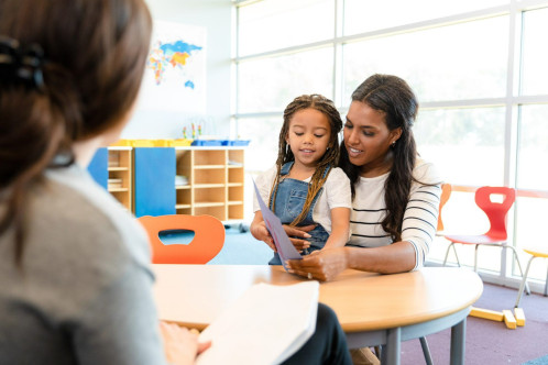 A parent and child sitting at a desk