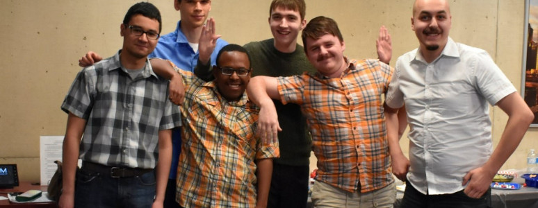 Group of adults standing beside each other.