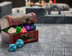 Pointed dice inside of a small treasure chest.