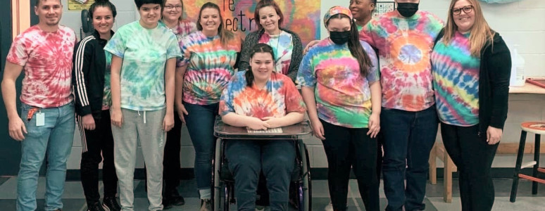 Group of adults standing beside each other.