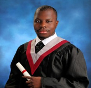 Ethan Jean-Baptiste wearing a graduation gown and holding a diploma
