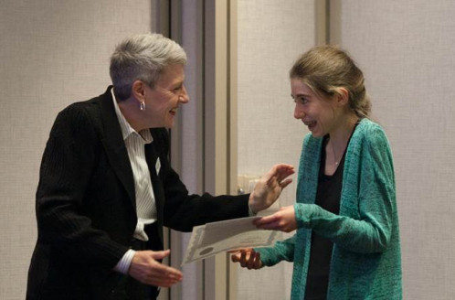 A woman presenting a scholarship to a student