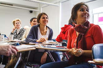 Four parents sitting at desks in a classroom