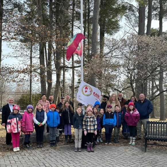 Group of students gathered around flagpole