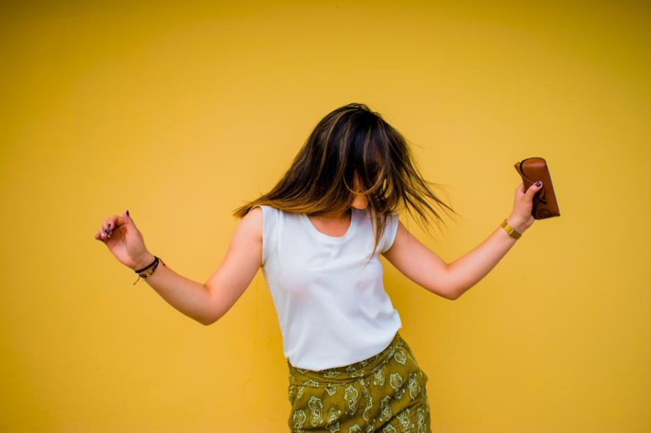 Girl dancing in front of yellow background