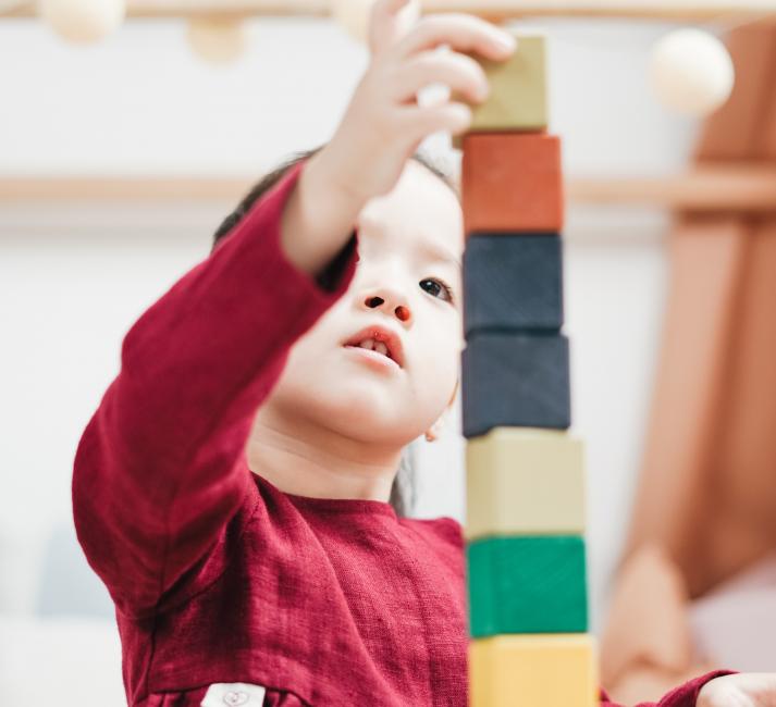 A young boy building a tower out of blocks