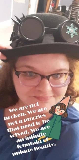 A woman with red hair wearing glasses and a bowler hat with steampunk goggles on them with words that are written below