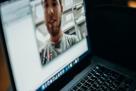 Open laptop with a window open of a guy on a video call